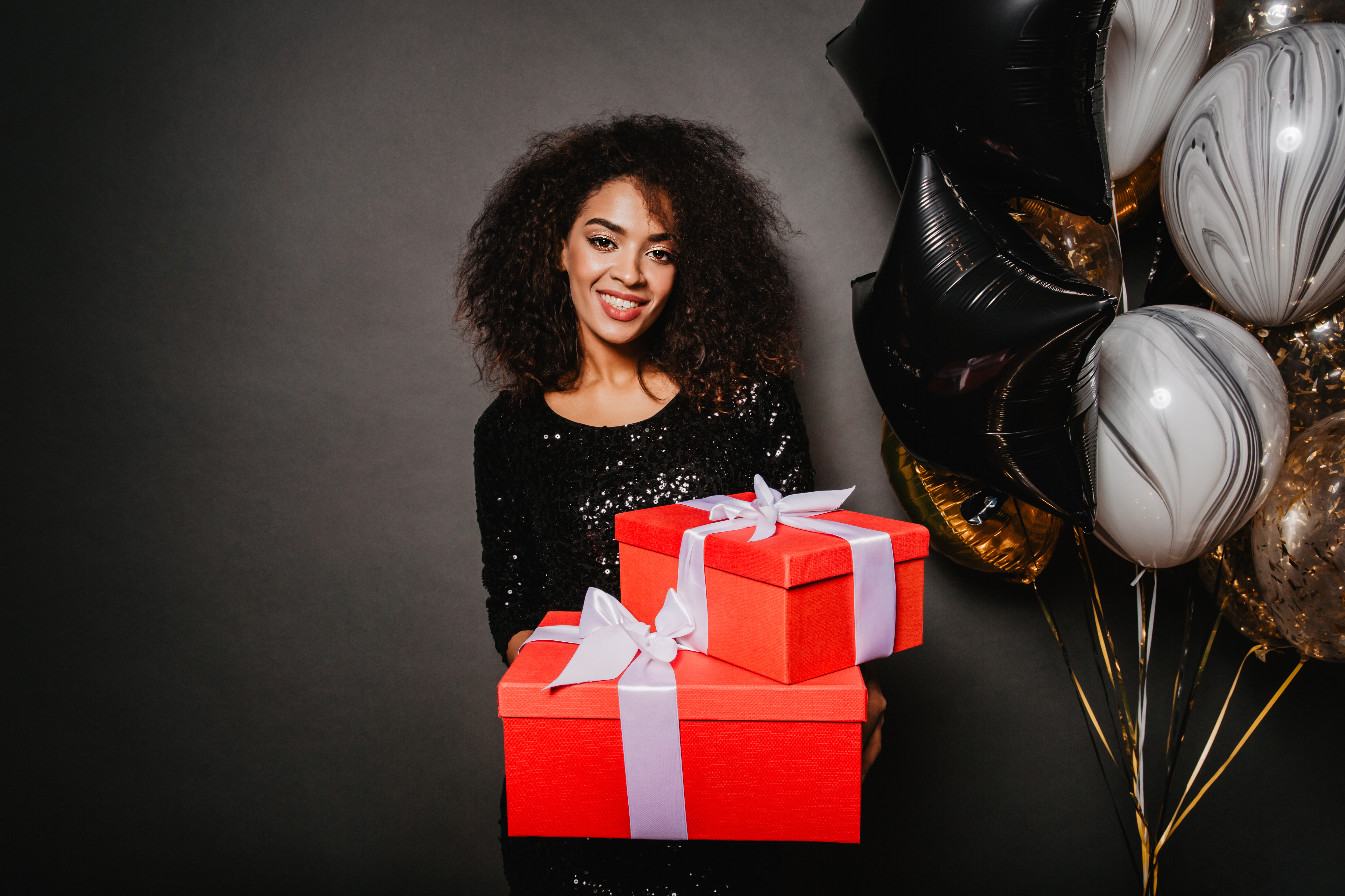 smiling woman holding birthday present Хубави неща - магазин за подаръци | hubavineshta.bg